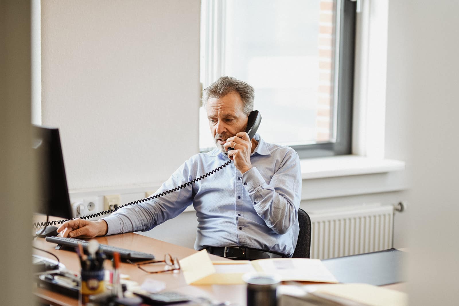 Bob Maassen aan de telefoon achter zijn bureau